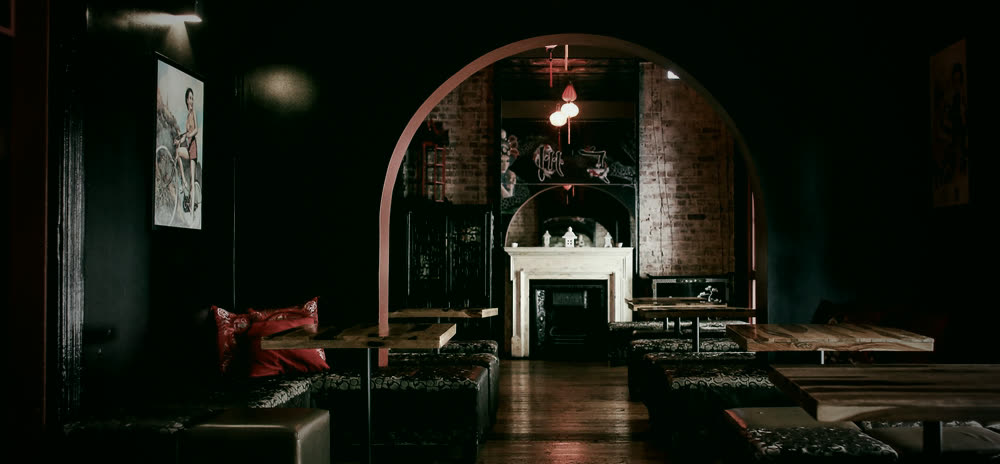 Concept image: a moody, low-lit lounge with warm accents and soft seating